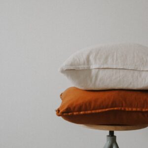 white pillow on brown wooden round table